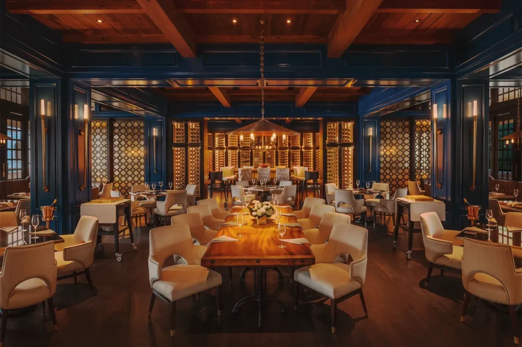 Upscale restaurant at Raffles Hotel Singapore with deep blue walls, warm lighting, and luxurious wooden interiors for fine dining.